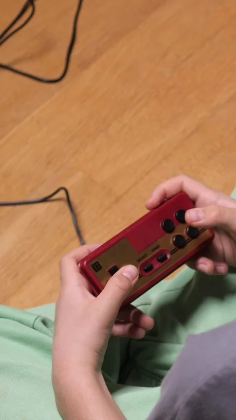 Vertical video Boy playing retro video games sitting on the floor 스톡 동영상 302657508