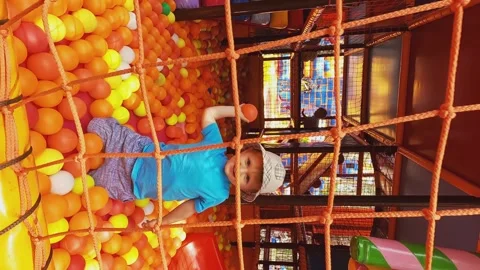 Vertical video - the boy plays with balls in the play center. Leisure activity Stock Footage 245454118