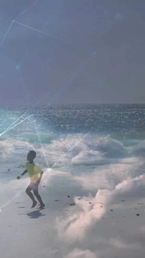 Vertical video: Boy running along beach, reacting to waves, tech overlay tracing Stock Footage 334547121