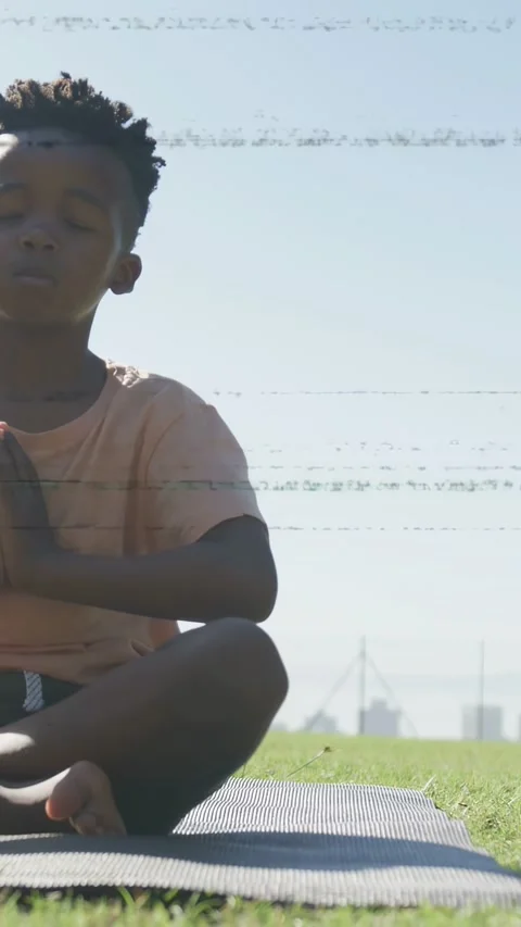 Vertical video: Boy sitting mat, raising arms then folding hands, breathing for Stock Footage 333496748