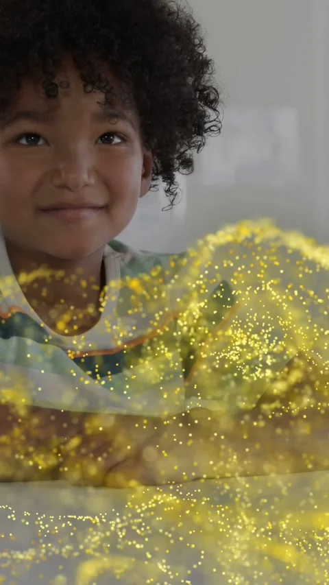 Vertical video: Boy sitting at table watching tech gold swirl appearing on cue Stock Footage 333862230