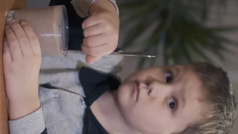 Vertical video of boy stirs milkshake Stock Footage 158676314