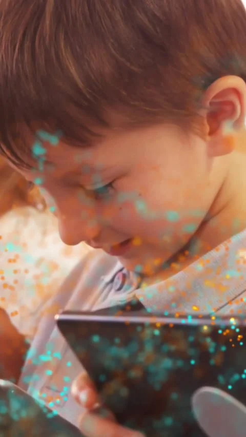 Vertical video: Boy tapping tab making dots on face growing-fading on zoom as Stock Footage 331580736