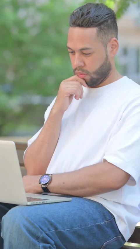 Vertical video, Brainstorming Young Man Reading on Laptop Outdoor Vídeo Stock 320245356