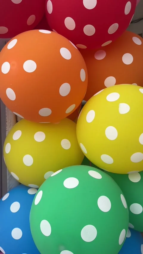 Vertical video of Bright polka dot balloons in pink red orange yellow Stock Footage 314098302