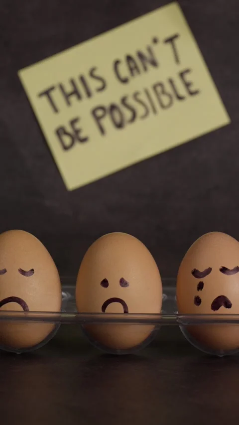Vertical video, brown eggs with sad faces drawn by hand, with a yellow note Stock Footage 281372776