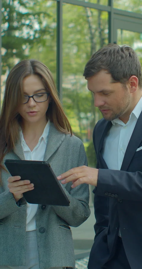 Vertical video. Business people going to work with digital tablet on street. Stock Footage 345586252