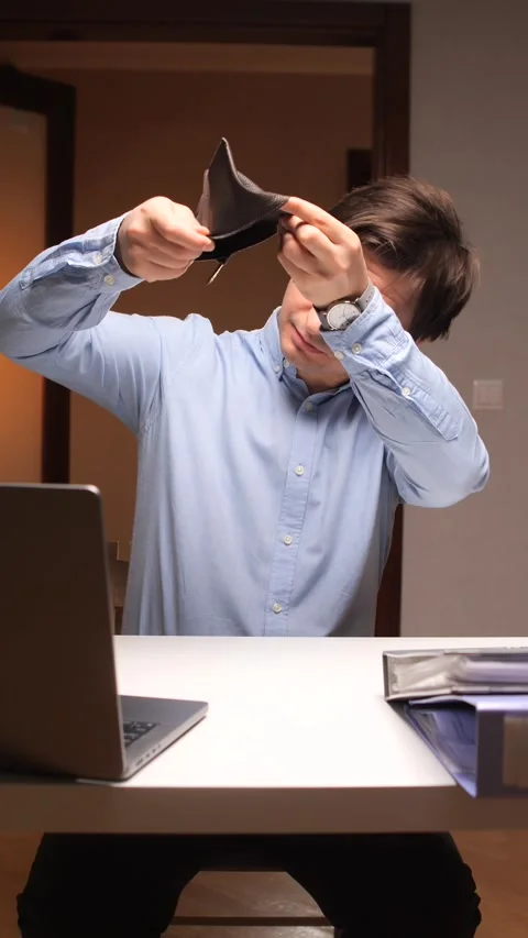 Vertical video Businessman checking empty wallet at office desk Stock Footage 307419446
