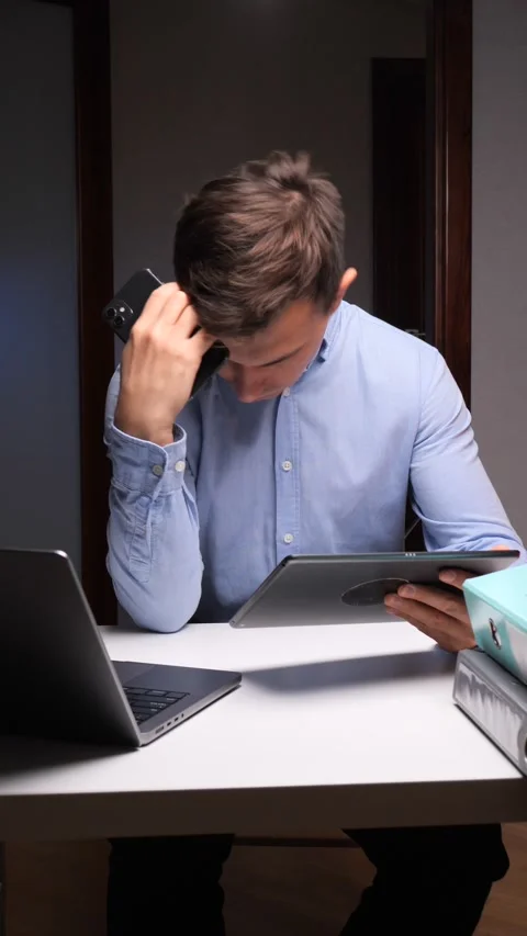 Vertical video Businessman multitasking with multiple devices experiencing Stock Footage 322912125