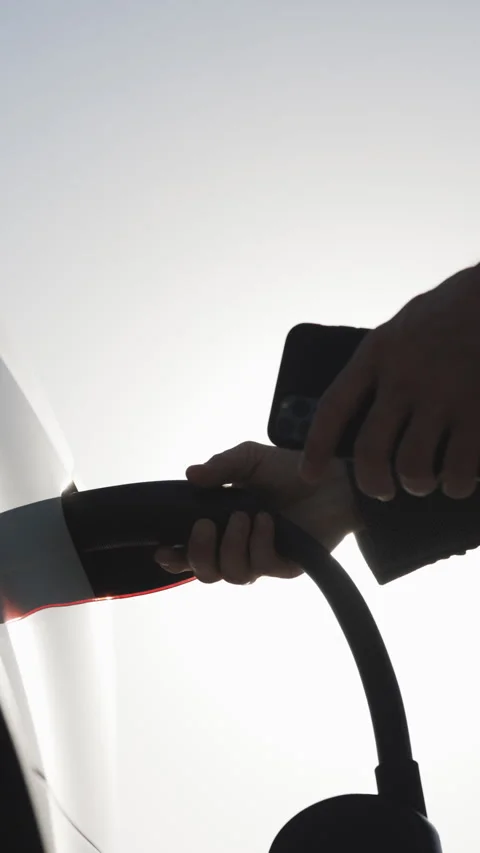 Vertical Video of businessman plugging electric car from charging station Stock Footage 302650189