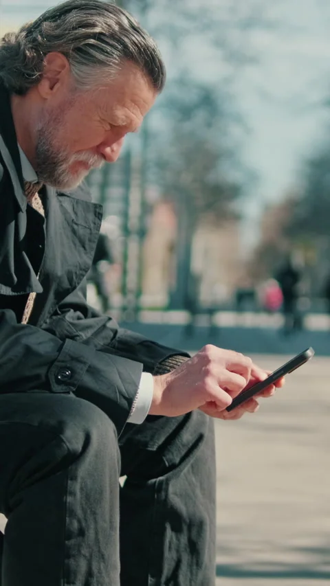 Vertical video, Businessman Using Phone on City Bench Stock Footage 312184345
