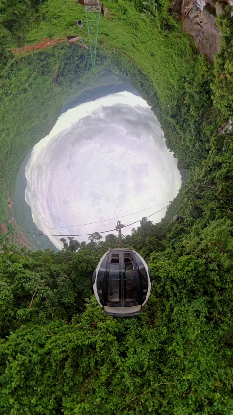 Vertical video. Cable Car Entering Deep Circular Forest Opening Captured in Hole Vídeos de archivo 323459409