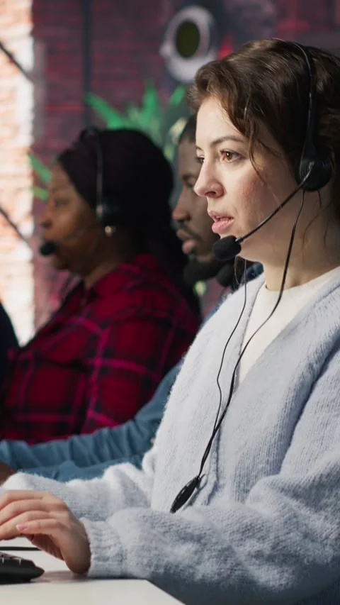 Vertical video Call center team of agents wearing headset assisting customers Stock Footage 306050239