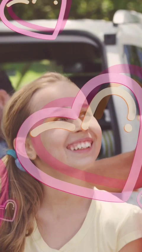 Vertical video: Cam pulling back showing girl holding straw hat pink hearts Stockbeeldmateriaal 334025517