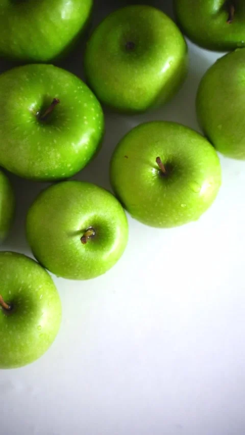 Vertical video - the camera focuses on the glossy surface of the green apples Stock Footage 310631101