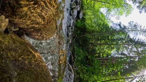 VERTICAL VIDEO, Camera moves in the water between stones in mountain river with Stock-Footage 252283418