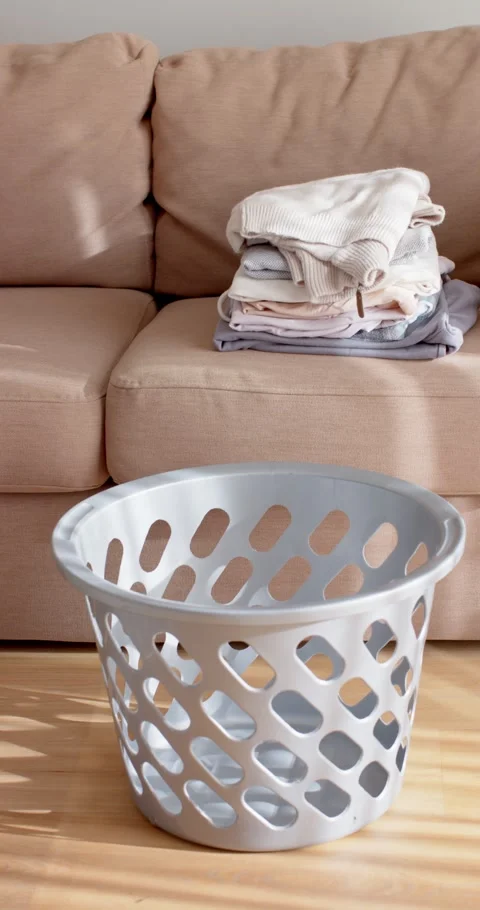 Vertical video: Camera is moving in, gray basket filling frame, folded stack on Stock Footage 345092586
