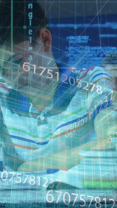 Vertical video: Camera panning showing male pupil writing at desk code overlay Stock Footage 331337119