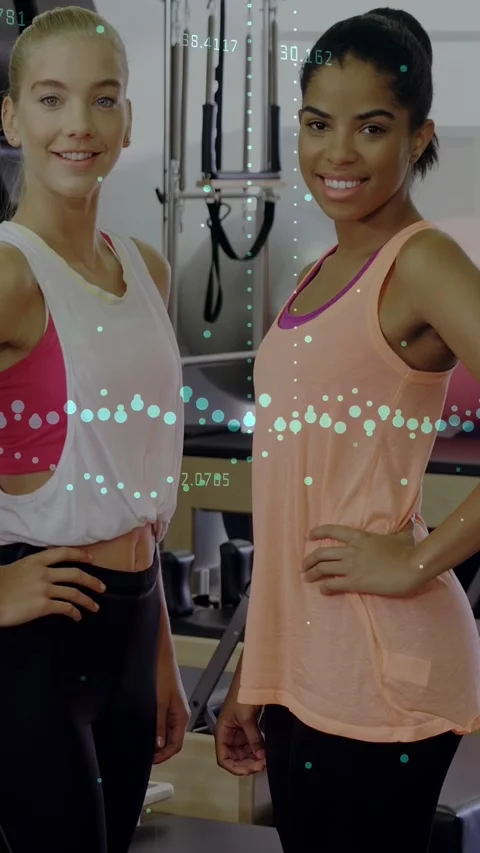 Vertical video: Camera tilting up, two women posing in gym near weights for Video stock 333079892