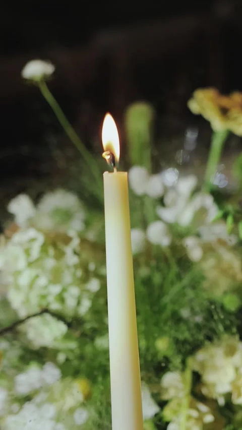 Vertical video. Candle against the background of floral arrangements at a Stock Footage 307918231