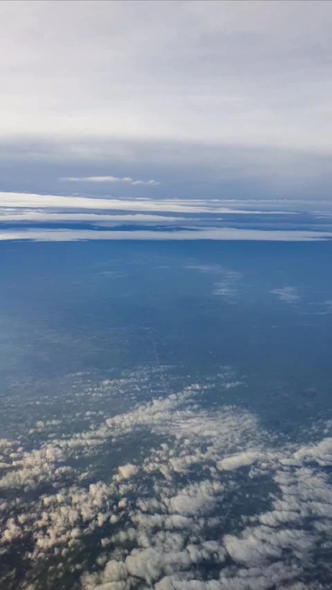 Vertical video captured from an airplane window showing a serene aerial view abo Stock Footage 331888131