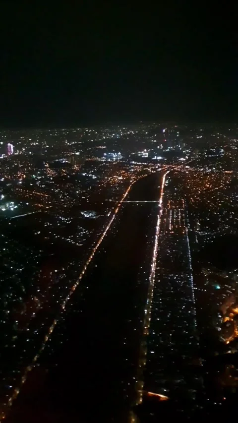 Vertical video captured from an airplane window during night flight, showing a g Stock Footage 331888146
