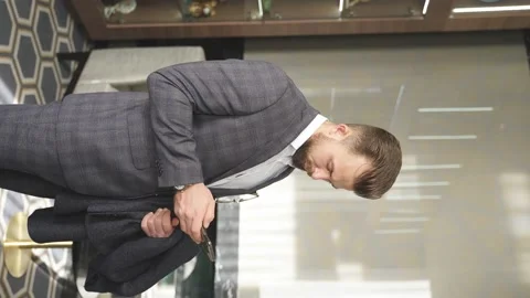 Vertical video of caucasian guy stands with smartphone in hotel lobby Stock Footage 150550448