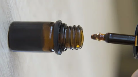 Vertical video of cbd Droplets of Hemp oil filling Dropper Bottle Stock Footage 231324095