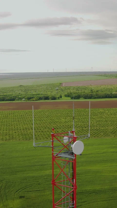 Vertical video. Cell tower on the background of green hills and sky Stock Footage 277865378