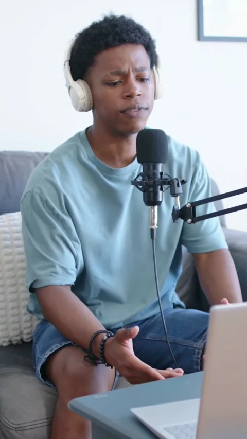 Vertical video: Checking laptop, creator recording audio on couch at home, using Stock Footage 348369714