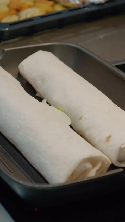 Vertical video Checking lavash kebabs for browning on a grill pan Stock Footage 329626452