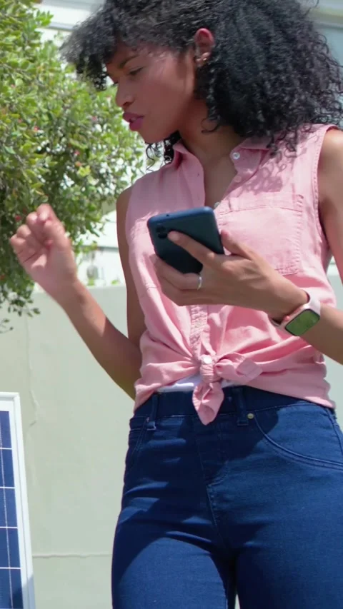 Vertical video: Checking phone for panel data, woman in pink shirt touching Stock Footage 348820954