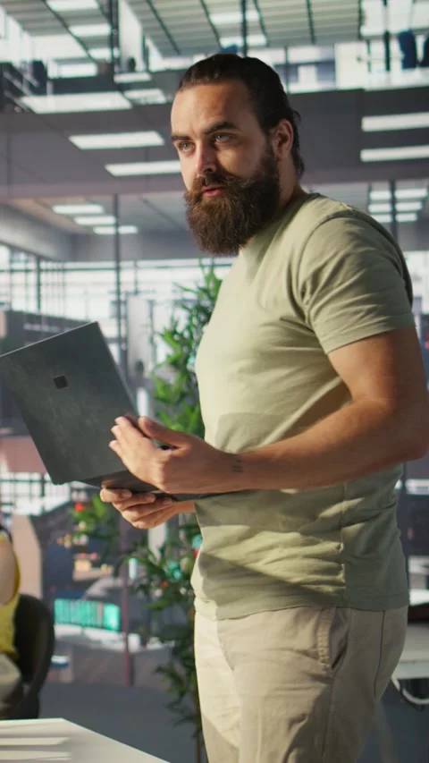 Vertical video Cheerful admin holding laptop chatting with colleagues while Stock Footage 319468665