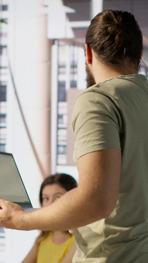 Vertical video Cheerful admin holding laptop chatting with colleagues while Stock Footage 319470139