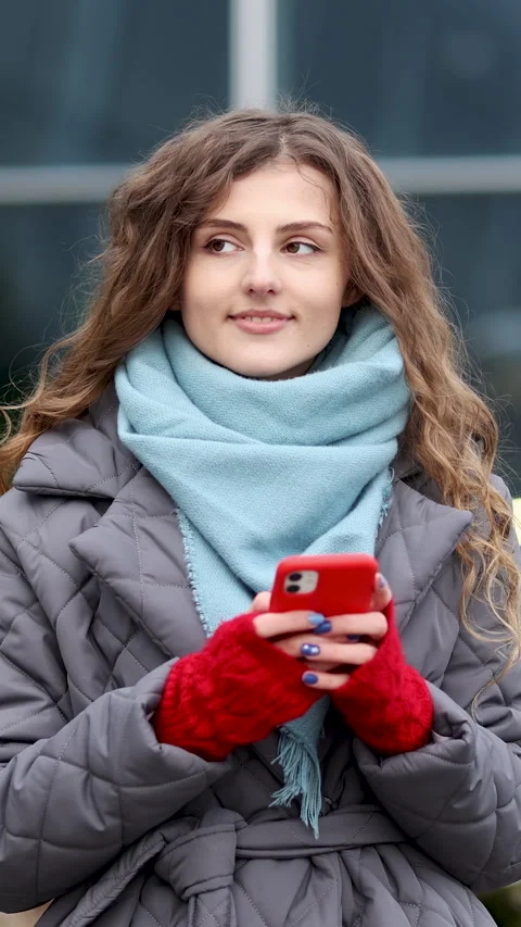 Vertical video of cheerful Curly-haired Young female texting on smartphone Stock Footage 302253802