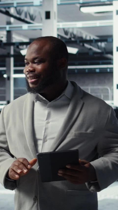 Vertical video Cheerful data center programmer using tablet to manage software Stock-Footage 311548104