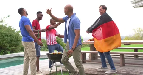 Vertical video: Cheering five men in red greeting flag-wrapped man approaching Stock Footage 344851780