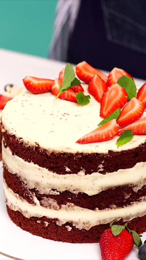 Vertical video of chef confectioner putting fresh strawberry slice on top of a Stock Footage 323179282