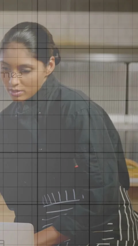 Vertical video: Chef at kitchen counter consulting laptop, managing prep tasks, Stock Footage 333487171