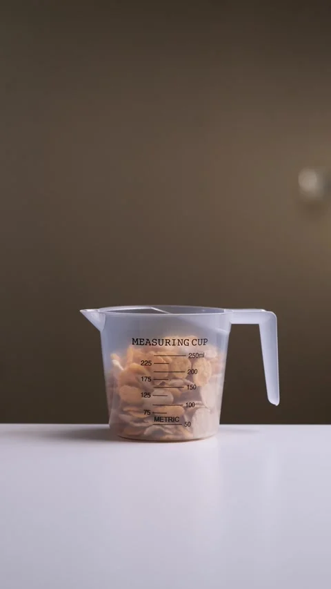 Vertical video Chef pouring corn flakes into measuring cup on kitchen counter Vidéo 303369073