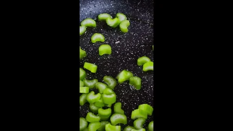 Vertical video. The chef pours sliced, celery stalks, into the hot pan. Stock Footage 302637171