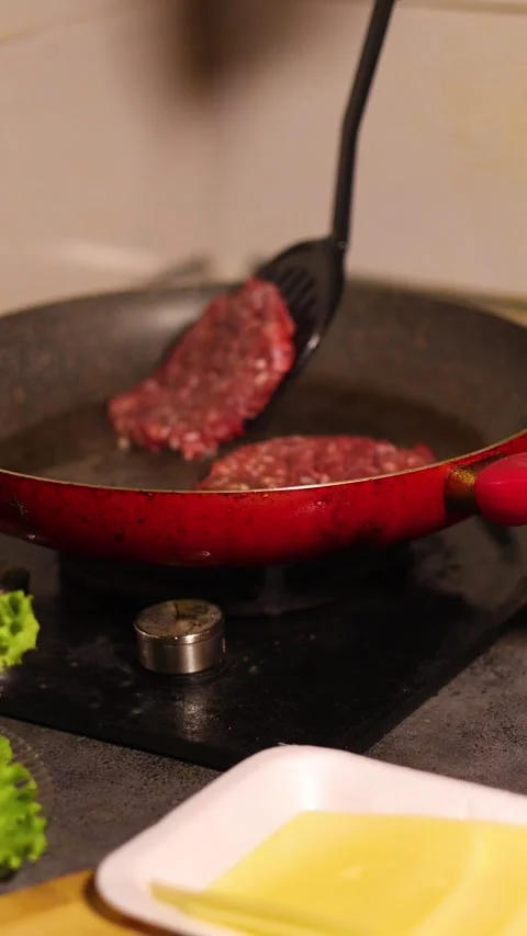 Vertical video. Chef puts cutlet on frying pan with spatula Stock Footage 326824607
