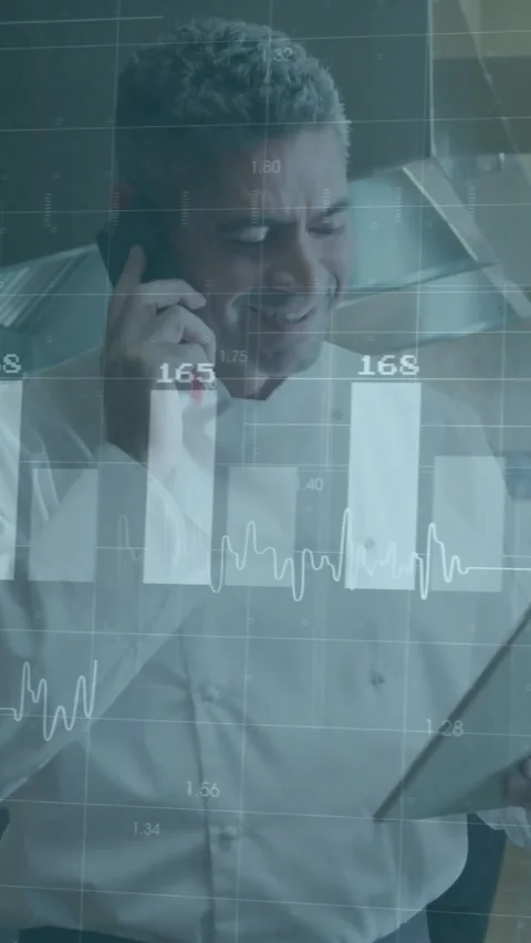 Vertical video: Chef taking call and checking sales on tablet in kitchen, charts 動画素材 331738924