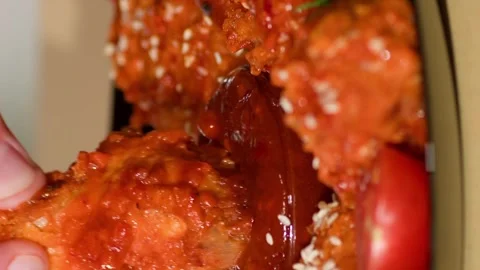 Vertical video. Chicken Wing is Dipped into a Ketchup Bowl on a Table. Video stock 250454866