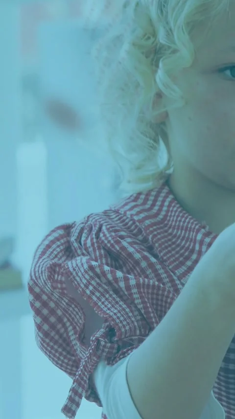 Vertical video: Child checking card near face lowering arm as dotted film Stock Footage 331790168