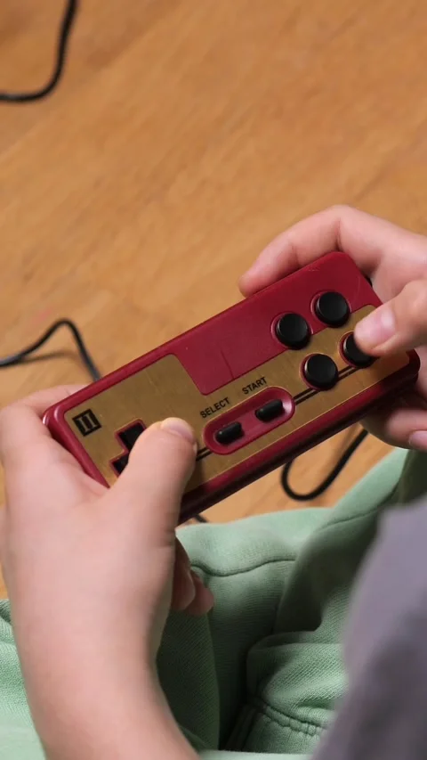 Vertical video Child playing retro video games using controller at home Stock Footage 302657525