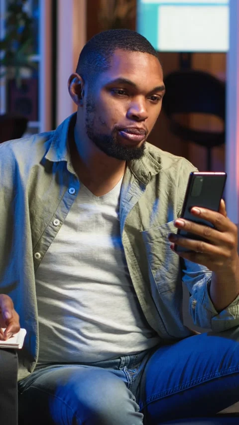 Vertical Video Chill self employed guy enjoying a video call on mobile phone at Stock Footage 308202654