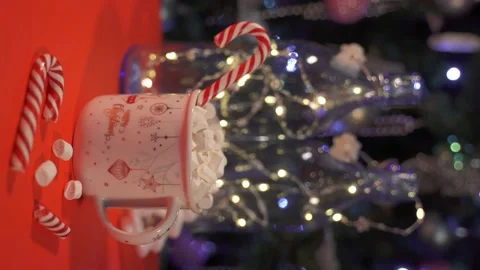 Vertical video. christmas mug with marshmallows and striped candy on the backgro Stock Footage 165535208