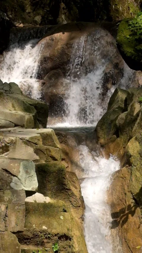 Vertical video of a clear mountain waterfall flowing through solid rock Video stock 321325530