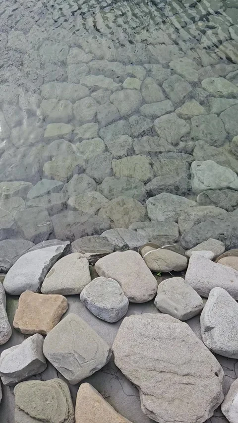 Vertical video of clear water flowing over large stones in an artificial pond Vídeos de archivo 336947716